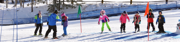 A ski and snowboard instructor teaches students how to ride on skis