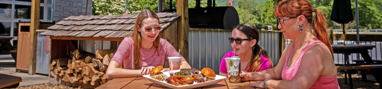 Three guests eating outside at Virginia BBQ & Pizza Co.