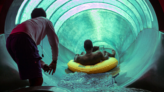 An employee helping guests down a tube slide at the Massanutten Indoor WaterPark