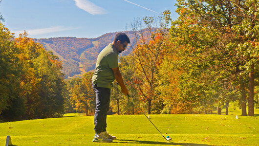 A man playing golf at Massanutten Resort during the fall season