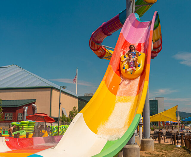 Two guests on a rainbow waterslide at the Massanutten Outdoor WaterPark