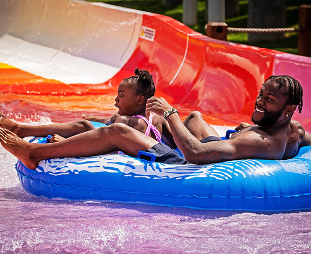 A daughter and father on a waterslide at the Massanutten Outdoor WaterPark