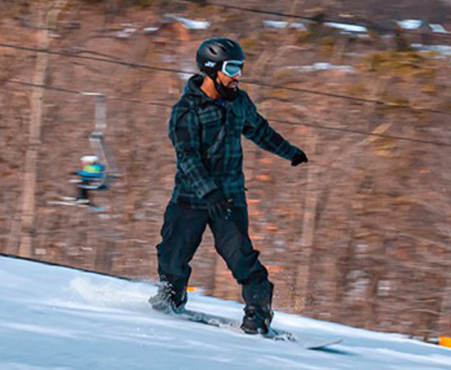 A man snowboarding at Massanutten Resort